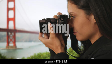 Libre d'woman taking photo avec votre appareil photo reflex numérique, près de Golden Gate Bridge Banque D'Images