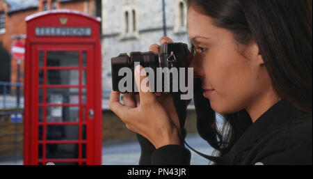 Vue de côté de la prise de photo sur l'Angleterre hipster rue avec cabine téléphonique rouge Banque D'Images