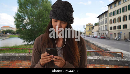 Femme à Florence sms et écouter de la musique avec le smartphone Banque D'Images