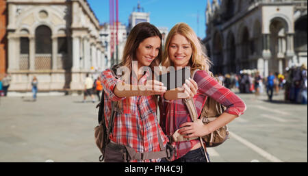 Couple de femmes backpackers à Venise en tenant vos autoportraits à la place St Marc Banque D'Images