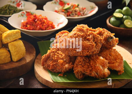 Geprek Ayam. L'alimentation de rue de fusion de poulet frit du sud avec des condiments épicés indonésiens de cuisines régionales. Banque D'Images
