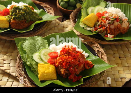 Geprek Ayam. L'alimentation de rue de fusion de poulet frit du sud avec des condiments épicés indonésiens de cuisines régionales. Banque D'Images