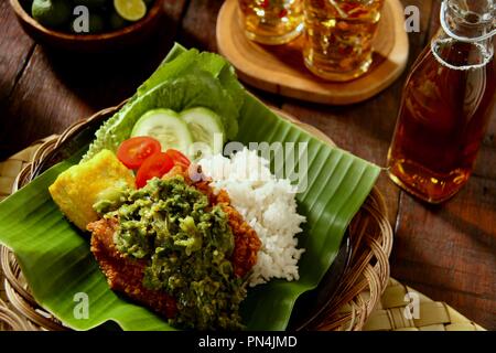 Geprek Ayam Sambal Lado Mudo. L'alimentation de rue Fusion plat de poulet frit du sud surmontée de Sambal Lado Mudo, la pâte de piment vert traditionnel. Banque D'Images