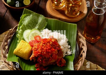 Geprek Ayam Balado. L'alimentation de rue Fusion plat de poulet frit du sud surmontée de Lado Sambal Sambal oelek ou, la traditionnelle pâte de piment rouge. Banque D'Images