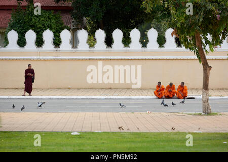 Rue comique tourné de jeunes moines bouddhistes aux extrémités opposées de l'armature devant le Palais Royal à Phnom Penh, Cambodge. Banque D'Images