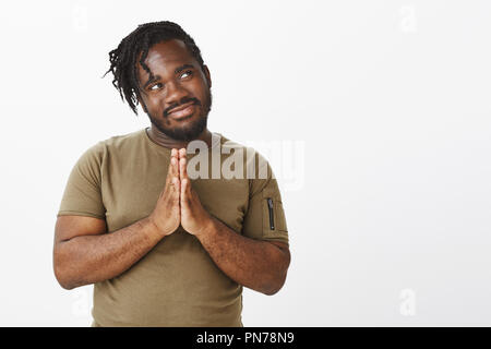 Avoir une grande idée qui soufflera l'esprit d'amis. Heureux l'homme afro-américain attrayant en tenue décontractée, tenant les mains en prière, se frottant les paumes et souriant au coin supérieur droit, avoir planifier Banque D'Images