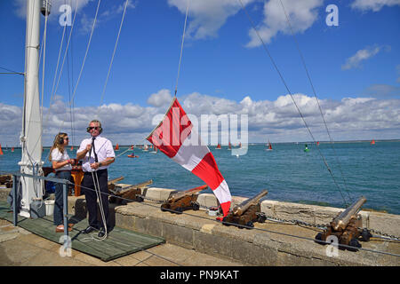 Fonctionnaires sur la ligne de départ du Royal Yacht Squadron, Cowes, soulevant le report d'un drapeau qui indique une course non commencé est reportée, l'OIEAU, UK Banque D'Images