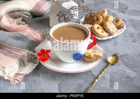 Chocolat chaud le matin dans la tasse blanche originale avec un bouton bleu sur le fond de biscuits. Le petit-déjeuner revigorant. Banque D'Images