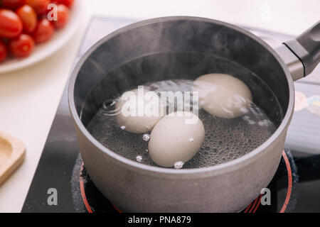 Trois oeufs dans la casserole d'eau bouillante Banque D'Images