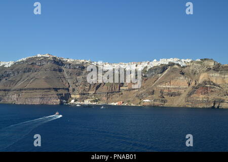 Vue magnifique sur la ville de Fira au sommet d'une montagne sur l'île de Santorin à partir de la mer, avec un bateau de transport de passagers. L'architecture, Banque D'Images