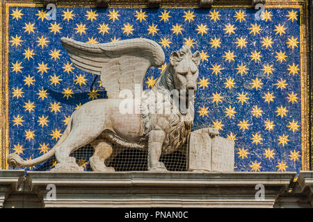 La lion dans la place San Marco, Venise, Italie. La statue est sur un fond bleu parsemé d'étoiles, avec une bible appuyée par une patte. Banque D'Images