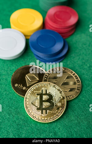 Bitcoin Litecoin, physique de l'or et l'Ethereum des pièces avec des jetons de casino sur fond vert. Jeu du marché des devises Crypto concept abstrait. Banque D'Images