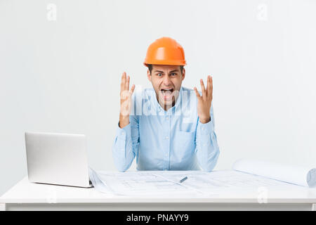 L'accent grave ingénieur travailleur occupé à travailler sur de grands projets architecturaux en retard, assis à son espace de travail à l'aide de digital tablet pc. Les gens, le travail, l'occupation et profession concept Banque D'Images