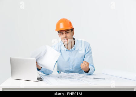 L'accent grave ingénieur travailleur occupé à travailler sur de grands projets architecturaux en retard, assis à son espace de travail à l'aide de digital tablet pc. Les gens, le travail, l'occupation et profession concept Banque D'Images