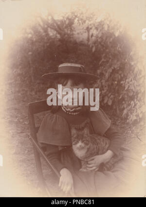 * Vintage photographie victorienne d'une jeune fille assise à l'extérieur tenant son animal chat tigré Banque D'Images