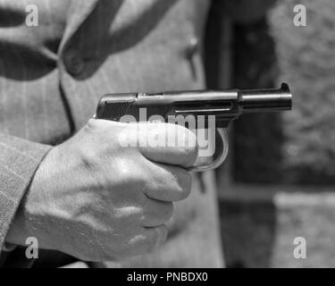 1930 MAN'S HAND HOLDING PISTOL DOIGT SUR LA DÉTENTE - un HAR1757001 PISTOLET illégal d'ARMES À FEU HARS NOIR ET BLANC DE L'ORIGINE ETHNIQUE CAUCASIENNE MAINS SEULEMENT HAR001 LE VOL À L'ANCIENNE Banque D'Images