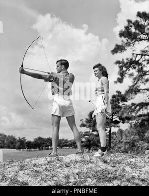 1930 TEENAGE COUPLE PRACTICING TIR TIR À L'arc et flèche - un941 HAR001 HARS JOIE VIE SANTÉ RURALE ESPACE COPIE PLEINE LONGUEUR D'AMITIÉ LES PERSONNES DE CONDITION PHYSIQUE TIR À L'ADOLESCENTE ADOLESCENT FLÈCHE ATHLETIC CONFIANCE B&W L'ACTIVITÉ COMPÉTENCES EN ÉTÉ LE BONHEUR D'AVENTURE PHYSIQUE RENFORCER L'ESTIME DE SOI LA FORCE DE LOISIRS PASSE-TEMPS ET INTÉRÊTS HOBBIES LOISIRS CONNAISSANCES PLAISIR PASSE-TEMPS FLEXIBILITÉ SANTÉ MENTALE ADOLESCENTS ÉLÉGANT MUSCLES COOPÉRATION SOLIDARITÉ ARCHERS RELAXATION JEUNES ADULTES JEUNES ADULTES FEMME HOMME NOIR ET BLANC AMATEUR L'ORIGINE ETHNIQUE CAUCASIENNE JOUISSANCE HAR001 Banque D'Images