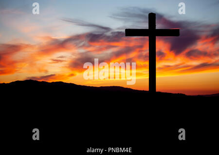 Thème de la religion, vue de la croix catholique en ombre noire, avec magnifique coucher de soleil avec des couleurs chaudes et les montagnes en arrière-plan, à Viseu, Portugal Banque D'Images