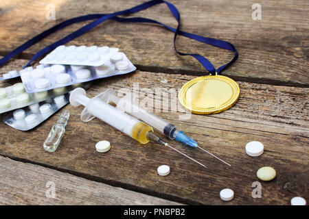 Médaille sportive et des médicaments sur un fond de bois. La tonalité de l'image. Banque D'Images