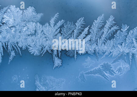 Bande de glace hiver blanc givré bleu sur vitre. Banque D'Images