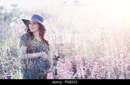 Fille enceinte dans un champ de fleurs Banque D'Images