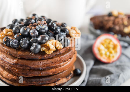 Pile de crêpes au chocolat maison avec des bleuets et de morceaux de chocolat, fond gris clair Banque D'Images