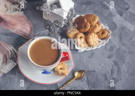 Chocolat chaud le matin dans la tasse blanche originale avec un bouton bleu sur le fond de biscuits. Le petit-déjeuner revigorant. Banque D'Images