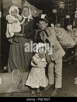 Famille d'immigrants, dans la salle des bagages d'Ellis Island. Date/période : 1905. Argentique. Largeur : 19,1 cm. Hauteur : 24,1 cm (feuille). Auteur : Lewis Hine. Banque D'Images