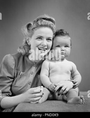 1940 SMILING BLONDE FEMME AVEC MÈRE TACAUD BABY GIRL SITTING ON TABLE LOOKING AT CAMERA - b9333 HAR001 HARS FEMELLES DU NOURRISSON SANTÉ ACCUEIL VIE COPIE Espace demi-longueur d'AMITIÉ MESDAMES FILLES EXPRESSIONS PERSONNES B&W CONTACT VISUEL À LA FOIS BONHEUR TACAUD UPDO ROULEAUX VICTOIRE JUVÉNILES CROISSANCE MAMANS TOGETHERNESS WOMAN NOIR ET BLANC bébé fille l'origine ethnique caucasienne HAR001 old fashioned Banque D'Images