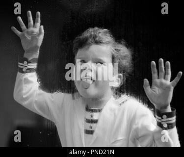 1930 rire étrange cheveux bouclés BOY WEARING STYLE NAUTIQUE SHIRT STICKING TONGUE ET PLAÇANT LES MAINS HUMIDES DE PLUIE SUR LA VITRE DE FENÊTRE - j2977 HAR001 style visage juvénile HARS ÉQUILIBRE HUMIDE SAUVAGE BANDE DESSINÉE RÉSUMÉ HEUREUX JOIE LIFESTYLE ACCUEIL ESPACE COPIE DE LA VIE DES HOMMES mi-longueur EXPRESSIONS NAUTIQUES B&W CONTACT OCULAIRE ÉTRANGE BIZARRE ÉTRANGE DÉCOUVERTE JOYEUSE STYLES ET CHOIX VOLET LOISIRS CURLY LOUFOQUES COLLER SUR DES SOURIRES JOYEUX CONCEPTUEL IDIOSYNCRASIQUE ÉLÉGANT APPUYANT SUR LA CROISSANCE DES juvéniles de la MODE EXCENTRIQUE AMUSANT NOIR ET BLANC présentant un comportement erratique de l'origine ethnique caucasienne HAR001 MISE À L'ANCIENNE Banque D'Images