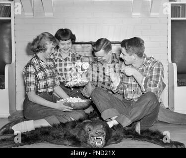 1950 ADOLESCENTS GROUPE POPCORN à éclater de rire POUR RIRE SOURIRE TAPIS PEAU D'OURS portant des jeans chemises à carreaux cheminée - j3743 FIL001 TAPIS D'ÉQUIPE HARS HEUREUX JOIE CÉLÉBRATION DE VIE SANTÉ LES FEMMES DE LA VIE DE L'AMITIÉ ESPACE COPIE PERSONNES DEMI-LONGUEUR HOMMES TISSU ADOLESCENT ADOLESCENTE PEAU DENIM PLAID POPCORN B&W BONHEUR SHIRTS JOYEUX SOURIRES POPPING ADOLESCENTS ÉLÉGANT BOBBY SOX JEANS BLEU BLAGUES JUVÉNILES UNITÉ PANIER EN FIL NOIR ET BLANC à l'ANCIENNE Origine ethnique Caucasienne Banque D'Images