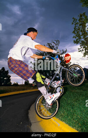 Années 1990, Young Man WEARING WHITE TEE SHIRT ET SHORT AVEC GENOUILLÈRES JUMPING LOCATION SUR TROTTOIR - KB29899 WAL004 TAMPON HARS ARRÊTER ÉQUILIBRE SAIN SÉCURITÉ FORTE CONCURRENCE DU GENOU SPORTIF FIT LA JOIE DE VIE DES PNEUS VTT ESPACE COPIE DANGER pleine longueur HOMMES ADOLESCENT RISQUE DE TRANSPORT PÉDALE PLAID ATHLÉTIQUE LIBERTÉ GUY QUARTIER DE COMPÉTENCES DE POINTE DE LA HANCHE FORCE AÉROBIE LOISIRS L'EXERCICE AÉROBIE SNEAKER STUNT JEUNE HOMME expérimenté l'excitation d'EFFORT D'INNOVATION LOISIRS PRISE SUR LE VÉLO LE VÉLO LOISIRS HABILE INTRÉPIDE MASCULIN BASEBALL HAT ÉLÉGANT CULTURE QUALIFIÉS STOP TROTTOIR T-shirt Freestyle compliqué Banque D'Images