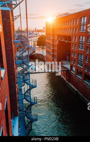 Escalier circulaire, pont sur canal et les bâtiments en brique rouge dans l'ancien quartier d'entrepôts Speicherstadt à Hambourg en heure d'or coucher de la lumière, de l'Allemagne. Vue de dessus Banque D'Images