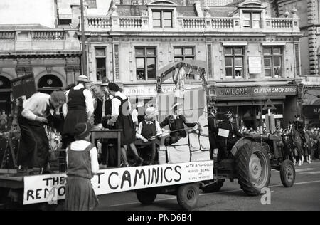 Années 1950, historiques, des étudiants universitaires s'habille dans drôle, costumes - basé sur l'Ronald Searle 'St' Trinians filles école- sur un char décoré ou une remorque tirée par un tracteur therough les rues pf Bristol, Angleterre, dans le cadre de la semaine de chiffon, une série d'événements de collecte de fonds organisées par les étudiants. Banque D'Images