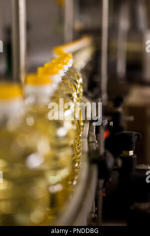 L'huile de tournesol dans la bouteille déménagement sur ligne de production. Shallow dof. Banque D'Images