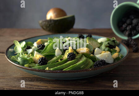 Salade d'œufs, la mâche et la roquette sur une plaque sur un vieux fond de bois Banque D'Images