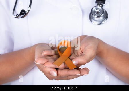 Close-up of main du médecin avec le ruban de la sensibilisation au cancer de l'utérus montrant Banque D'Images