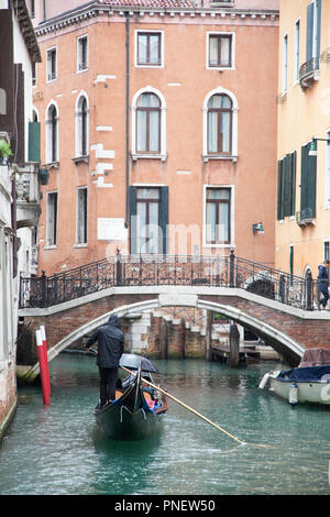 Un couple romantique en gondole à travers les canaux de Venise au cours de la pluie Banque D'Images