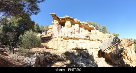 Une roche rouge en saillie avec des arbres et un ciel bleu profond dans le style canyon hills de Anento, petite ville de l'Aragon, Espagne Banque D'Images