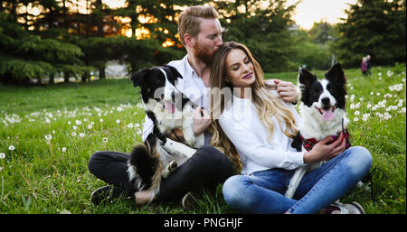 Beautiful couple walking dogs et le collage dans la nature Banque D'Images