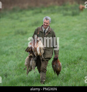 Homme portant sur un tournage faisans morts Banque D'Images