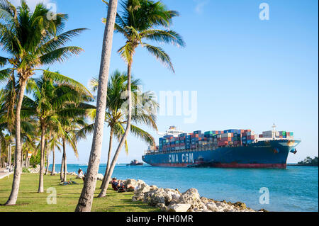 MIAMI, USA - circa 2018, août : navire 'conteneurs CMA CGM MUSSET' entrée au port par un étroit canal bordé de palmiers, à l'extrémité de la Plage Sud Banque D'Images