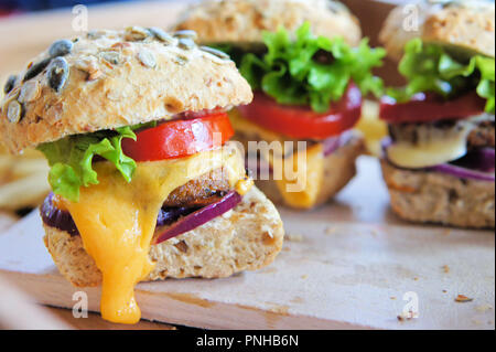 Plusieurs petits curseurs cheeseburger fabriqués à partir de galettes de ver. Les burgers sont faits d'insectes les vers Buffalo, qui sont les larves de l'darkling Banque D'Images