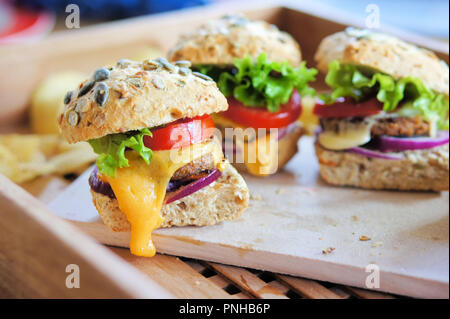 Plusieurs petits curseurs cheeseburger fabriqués à partir de galettes de ver. Les burgers sont faits d'insectes les vers Buffalo, qui sont les larves de l'darkling Banque D'Images