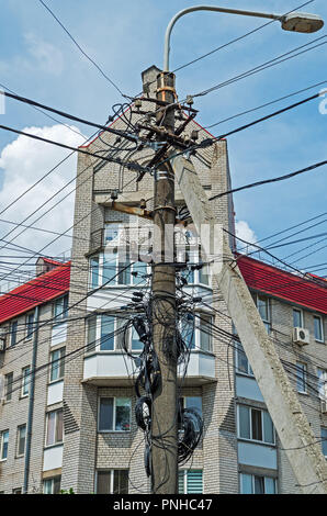 L'accumulation de nombreux fils électriques et connecté sur un poste d'éclairage de rue Banque D'Images