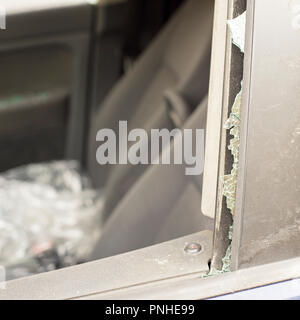 Voleur brisé la vitre de porte avant d'une voiture. Banque D'Images