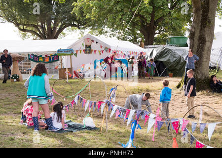 Chepstow, Pays de Galles - 19 Août 16 : garçon joue sur une balançoire fait maison au milieu d'un cercle d'enfants dans l'aire de jeux pour enfants le 16 août 2015 au Green Gathering Festival Banque D'Images