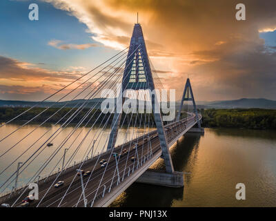 Budapest, Hongrie - Pont Megyeri sur Danube au coucher du soleil avec une circulation intense et magnifique ciel bleu et orange Banque D'Images