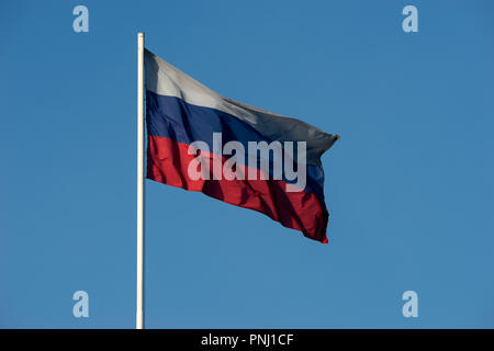 Drapeau russe de trois couleurs rouge, bleu, blanc de vagues dans le vent sur fond de ciel bleu clair et propre. Espace libre pour saisir du texte Banque D'Images