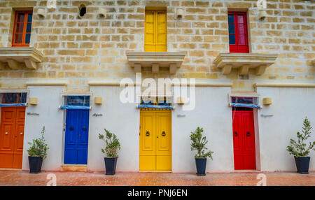 Portes et fenêtres colorées sont trouvés sur un bâtiment dans le port du petit village de pêcheurs de Marsaxlokk, Malte Banque D'Images